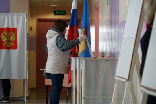 Женщина опускает бюллетень в урну на одном из избирательных участков Анадыря